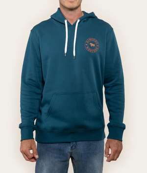 A person wears the Ringers Western Signature Bull Hoodie, a teal cotton design featuring front pocket and white drawstrings, with a "RINGER WESTERN" logo and animal graphic on the left chest. Paired well with blue jeans, it balances style and comfort.