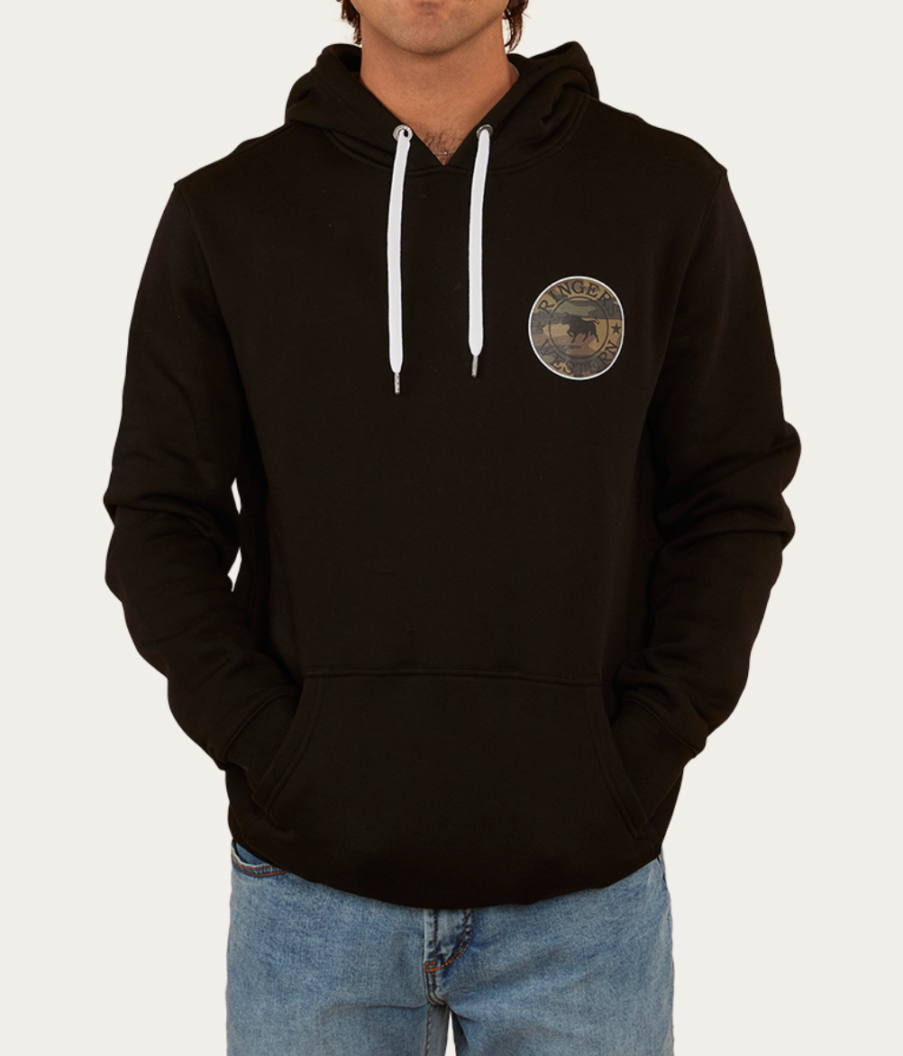 A person wears a black Ringers Western Signature Bull Hoodie, crafted from soft cotton, featuring a round "RANGER" logo with a horse. It has white drawstrings and a front pocket, paired effortlessly with blue jeans.
