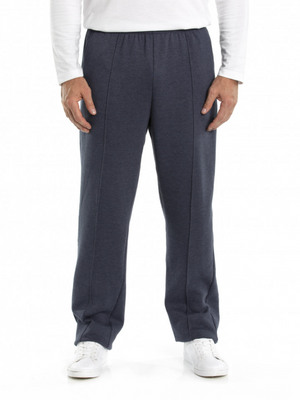 A person is wearing a white long-sleeve shirt, Breakaway Snowy Mt Fleece Pant in dark blue, and white sneakers. The image focuses on the individual from the shoulders down, showcasing the front view of this casual weekend wear against a plain white background.