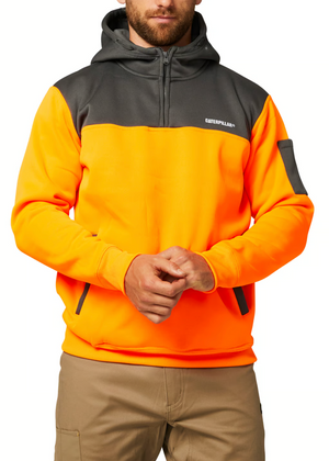 A person is wearing a CAT Hi Vis Hoodie in bright orange and gray with fleece lining and "Caterpillar" on the chest. The hoodie, featuring a front pocket, is paired with khaki trousers as they lightly clasp their hands.
