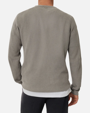 A person seen from behind wears the Industrie The Washed Culver Knit, a grey textured, long-sleeve shirt over a 100% cotton white t-shirt, paired with dark pants. The comfortable outfit is showcased against a plain white background.
