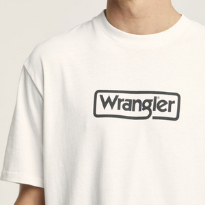 A person wears a Wrangler Border Tee in a regular fit, featuring the iconic black logo on the front. Made from 100% cotton, this white T-shirt stands out against the plain background.