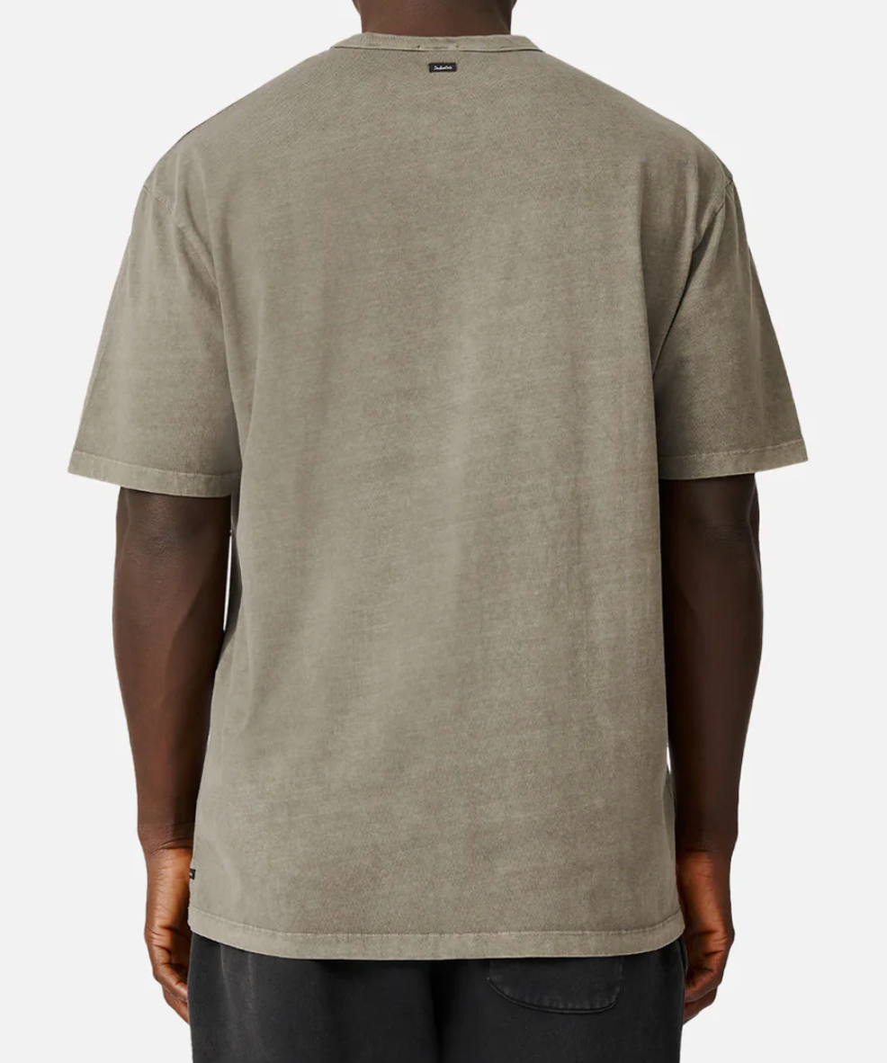 Rear view of a person in an oversized, comfortable Industrie The Del Sur Tee, acid wash gray, paired with black pants. The shirt has a small label at the back of the neck against a plain white background.