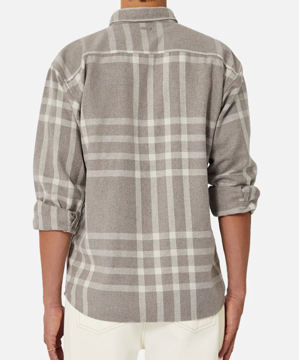 Wearing Industrie The Branford Shirt, a stylish regular-fit gray plaid with rolled-up cuffs, a person stands back to the camera, paired with white pants against a plain white background.