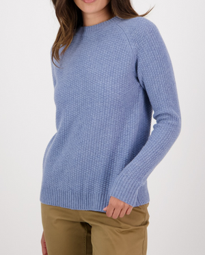 A person wearing the Swanndri Hayes Park Waffle Knit Crew in light blue and beige pants is standing against a plain white background. The image is cropped from the shoulders down, making the person's face not visible.