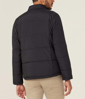 A man is seen from behind wearing the NNT Puffer Jacket in black with 3M Thinsulate, paired with beige pants, standing against a plain light background.