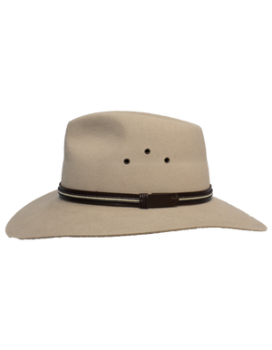 The Sovereign Cattleman, a beige wide-brimmed hat made from rabbit fur felt, features three side ventilation holes and a dark brown leather band with a small decorative piece, all while maintaining its classic structured design.