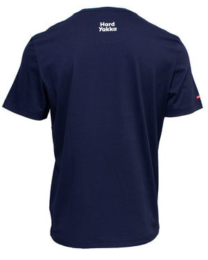 The Hard Yakka Crew Neck T-Shirt, depicted from the back, is a navy blue short-sleeve shirt featuring "Hard Yakka" printed in white text at the top near the neckline. A small red and white tag can be seen on the left sleeve.