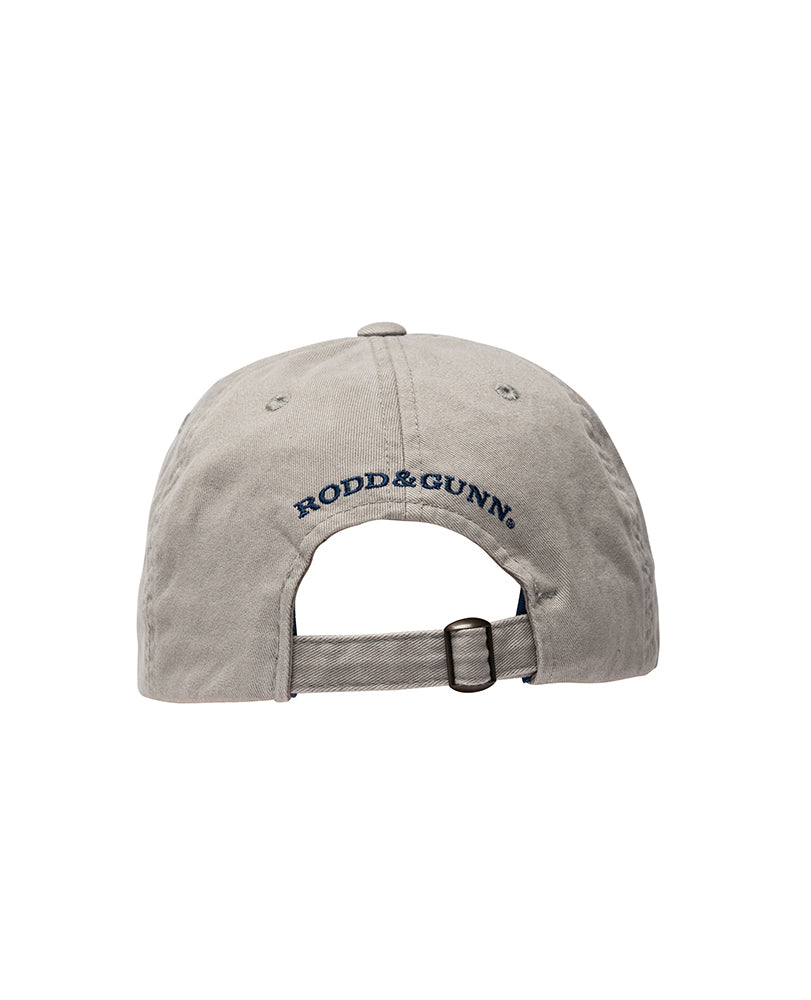 The Rodd & Gunn Signature Cap, in gray cotton twill, is shown from the back with an adjustable strap and metal buckle. "RODD & GUNN" is embroidered in navy blue thread above the opening.