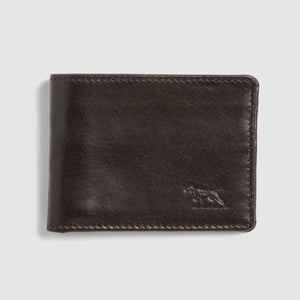 The Rodd & Gunn Victoria Flats Road Wallet, in a closed configuration, boasts a dark brown hue and is meticulously crafted from genuine buffalo leather with prominent stitching along the edges. An embossed animal logo is subtly positioned on the lower right corner. The background is light gray.