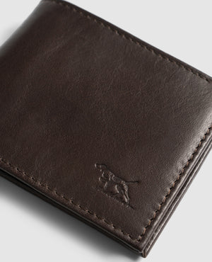 Close-up of a Rodd & Gunn Leeston Dunsandel Road Wallet in dark brown Buffalo Leather with stitched edges and an embossed running dog logo in the lower right corner. It features card slots and a coin pocket against a plain light gray background.