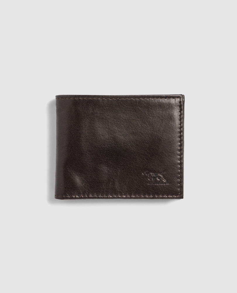 The Rodd & Gunn Leeston Dunsandel Road Wallet is a closed dark brown Buffalo Leather wallet, featuring a subtly embossed animal logo on the bottom right corner against a light gray backdrop. It boasts a smooth, slightly shiny texture with card slots and a coin pocket for practicality.