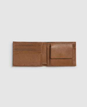 The Rodd & Gunn Leeston Dunsandel Road Wallet, made of brown buffalo leather, sits open on a gray background. It features multiple card slots on the left and a convenient flap-covered coin pocket on the right, with interior stitching enhancing the smooth leather texture.