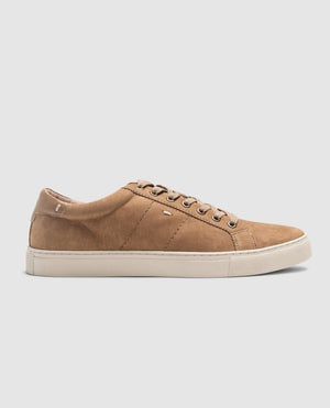 The Rodd & Gunn Endeavour Spirit Sneaker, featuring a tan nubuck leather with a suede-like texture and white soles, is set against a light gray background. It showcases six eyelets with brown laces and subtle side stitching details.