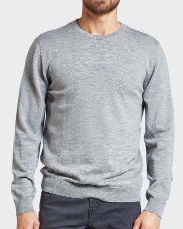 A person wearing the Academy Brand Academy Merino Crew stands against a plain, light background. Their light gray crew neck jumper, crafted from premium Australian Merino Wool, pairs perfectly with dark pants, while their face is partially cropped out of the frame.