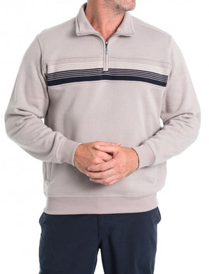 A man is wearing a "Breakaway Leo Snowy Mt Fleece Half Zip" in light beige with horizontal navy stripes across the chest. He is standing against a plain white background with his hands clasped in front of him, also dressed in dark blue pants. While his face isn't visible in the image, this winter staple radiates warmth and style.