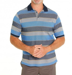 A man stands with clasped hands, wearing the Breakaway Tyrel Micro Prima Polo—a casual, short-sleeved blue and gray striped cotton shirt with a dark collar—and gray pants against a plain white background.