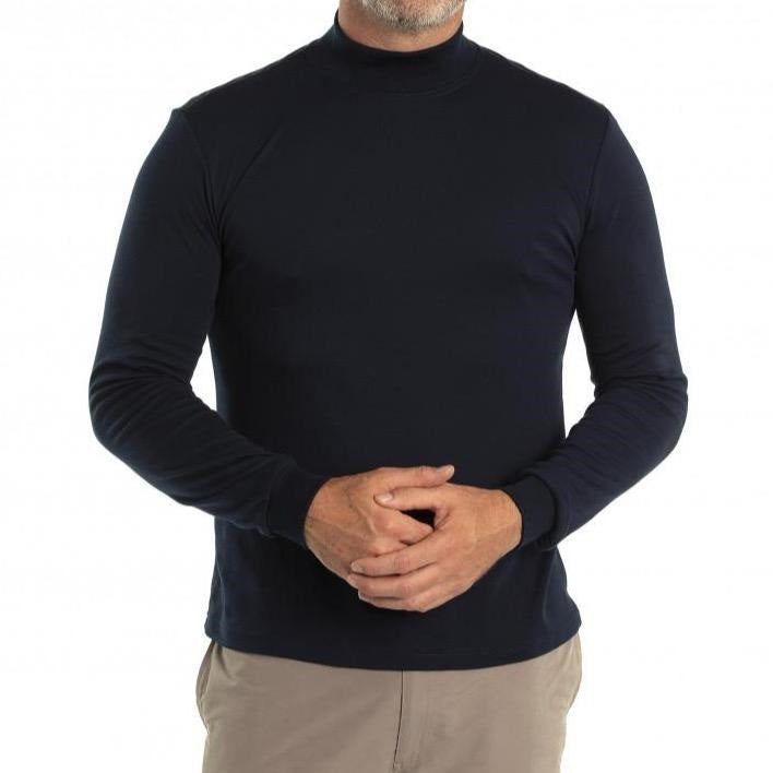 A person wearing the Breakaway Skivvy, a black turtleneck sweater crafted from a polyester and cotton blend, paired with light beige pants, is standing against a white background. The person is cropped just below the shoulders and their hands are clasped together in front.