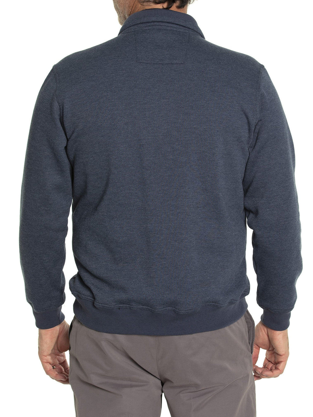 A person wearing the Breakaway Zed Snowy Mt Fleece Half Zip, a dark blue long-sleeve pullover, stands with their back to the camera, illustrating its ideal layering potential. Paired with gray pants, this outfit contrasts elegantly against a plain white background.