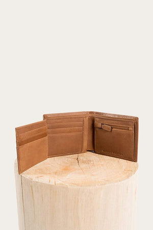 The Ringers Western Bayview Wallet, made from genuine leather, is stylishly open on a wooden pedestal against a plain backdrop. This brown wallet includes multiple card slots and a special compartment for bills.