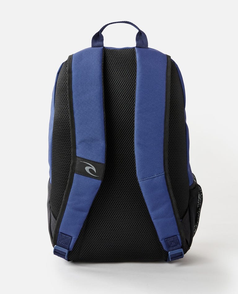 The Rip Curl Evo 24L Hope Eco Backpack, in blue and black, has adjustable straps with a small logo. It features padded mesh material for comfort and a laptop section, positioned upright against a plain white background.