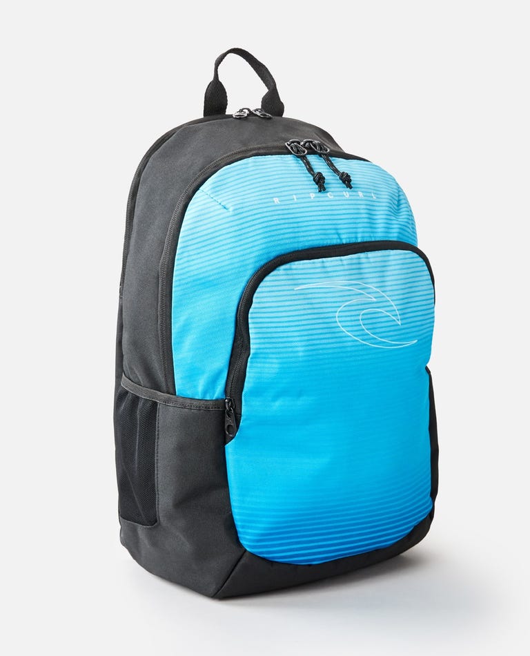 The Rip Curl Ozone 30L School Eco Backpack is made from recycled plastic and features a black and blue design, with a large front pocket showcasing a subtle wave pattern. It includes a top handle, adjustable shoulder straps, dual zipper closures, and an internal laptop compartment for added convenience.