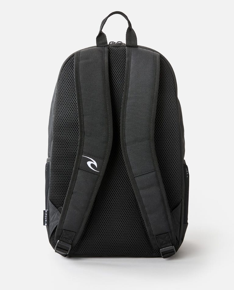 The Rip Curl Ozone 30L School Eco Backpack, made from recycled plastic, is displayed from the back. It includes two padded shoulder straps with a logo on the right one, a grey mesh back panel for ventilation, and a top handle. A laptop compartment is inside. The background is plain white.