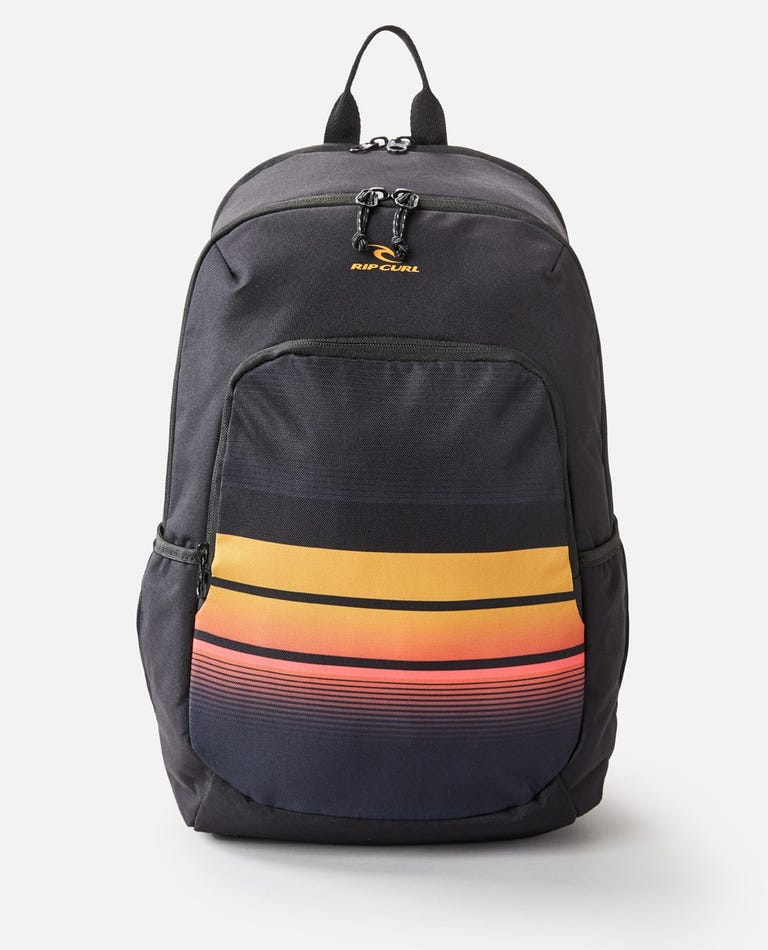 The Rip Curl Ozone 30L School Eco Backpack, made from recycled plastic, features a black exterior with a vertical zipper, two side pockets, and a front pocket with horizontal stripes in orange, yellow, and red. It also has a laptop compartment for easy storage.