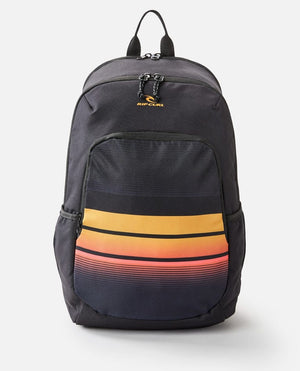 The Rip Curl Ozone 30L School Eco Backpack, made from recycled plastic, features a black exterior with a vertical zipper, two side pockets, and a front pocket with horizontal stripes in orange, yellow, and red. It also has a laptop compartment for easy storage.