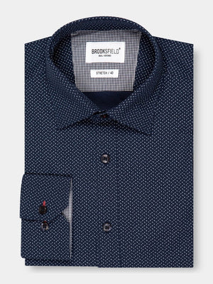 Dark blue long-sleeve Brooksfield Stretch Print Shirt with small white polka dots, buttoned and neatly folded for comfort. A tag inside the collar displays "BROOKSFIELD," offering additional sizing information.