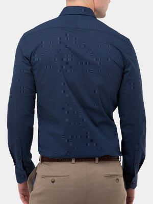 A man with short hair is wearing a navy Brooksfield Stretch Print Shirt, tucked into beige pants with a brown belt, against a plain white background.