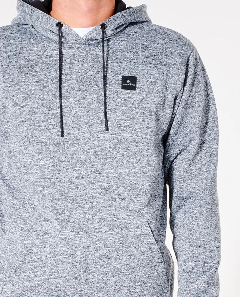 A person wears a light gray, speckled Rip Curl Anti Series Crescent Hood with drawstrings and a small black logo on the left chest. The durable water-resistant material and Anti Series technology enhance functionality. The plain white background highlights only the upper body.
