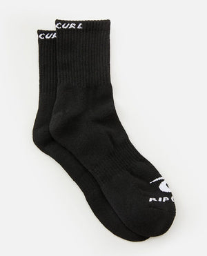 The Rip Curl Corp Crew Sock 5 Pack features pairs of black socks with white branding. The logo and text "RIP CURL" are visible on the top rim and near the toe area of each sock. Designed for men's sizes 9-13, these socks have a ribbed texture at the cuff and a smooth finish below the ankle.