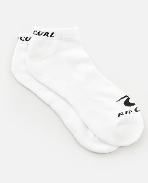 A pair of Rip Curl Corp Ankle Sock from the 5 Pack, in white with "RIP CURL" text and logo in black on the toe area, featuring arch support for added comfort. The socks are neatly laid out against a plain white background, positioned slightly overlapping each other.
