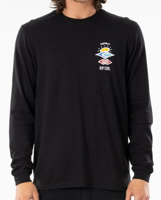 A person wears the Rip Curl Search Icon Long Sleeve Tee, a black casual shirt with a colorful abstract logo and "RIP CURL" on the left chest. Made from organic cotton, it's paired with dark pants against a plain white background.