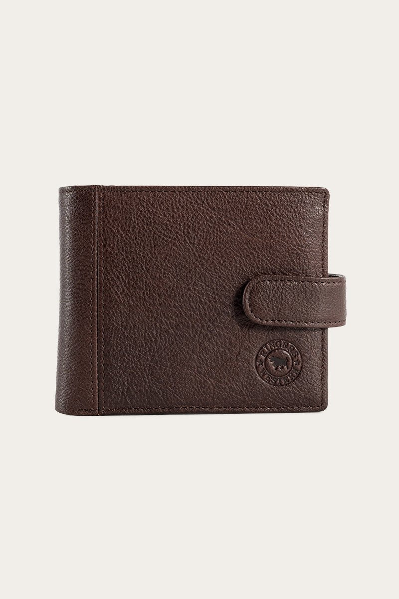 The Ringers Western Cypress Wallet, made from genuine leather with a textured surface, has a snap closure and features a circular embossed logo in the lower right corner, pictured against a plain background.