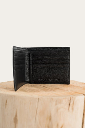 A textured black Ringers Western Duke Wallet is open, revealing multiple card slots inside. It is displayed standing on a light wooden surface with a neutral background. The brand name "HINGE & LIFTON" is embossed on the lower right corner of this genuine leather wallet.