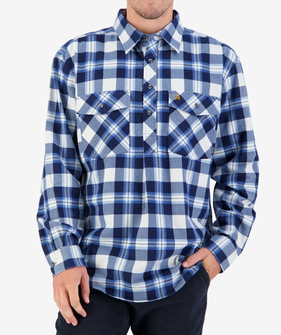 A person wears a Swanndri Egmont Flannelette button-up in blue and white plaid, their hand in the pocket of black pants. This long sleeve shirt has two chest pockets with buttons, though their head is not visible.