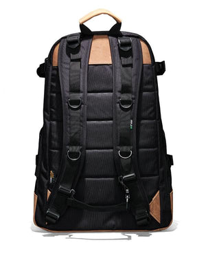 The FXD WBP-3 Work Backpack, in black with brown accents, is shown from the back with padded shoulder straps and multiple adjustment buckles. Made from durable Cordura Ballistic Fabric, it has a sturdy top handle, leather base for resilience, and a quilted back panel for comfort.