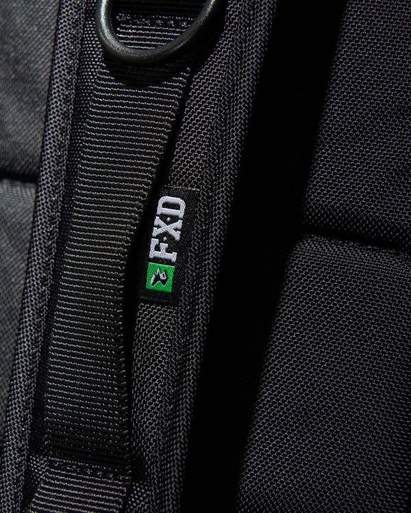 Close-up of a black Cordura Ballistic Fabric strap with a small black label showing the white text "FXD" and a green-black logo. The textured material pairs with a metal ring on the strap, integrating neatly into your FXD WBP-3 Work Backpack.