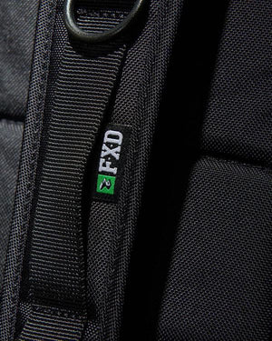 Close-up of a black Cordura Ballistic Fabric strap with a small black label showing the white text "FXD" and a green-black logo. The textured material pairs with a metal ring on the strap, integrating neatly into your FXD WBP-3 Work Backpack.