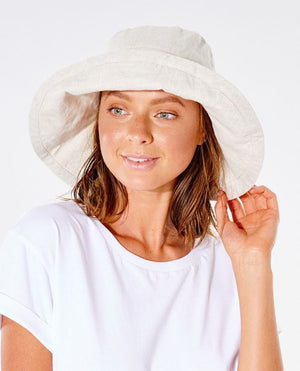 A person wearing a white Rip Curl Tres Cool UPF Sun Hat and a white T-shirt smiles softly while tilting their head slightly to the side against a plain white background.