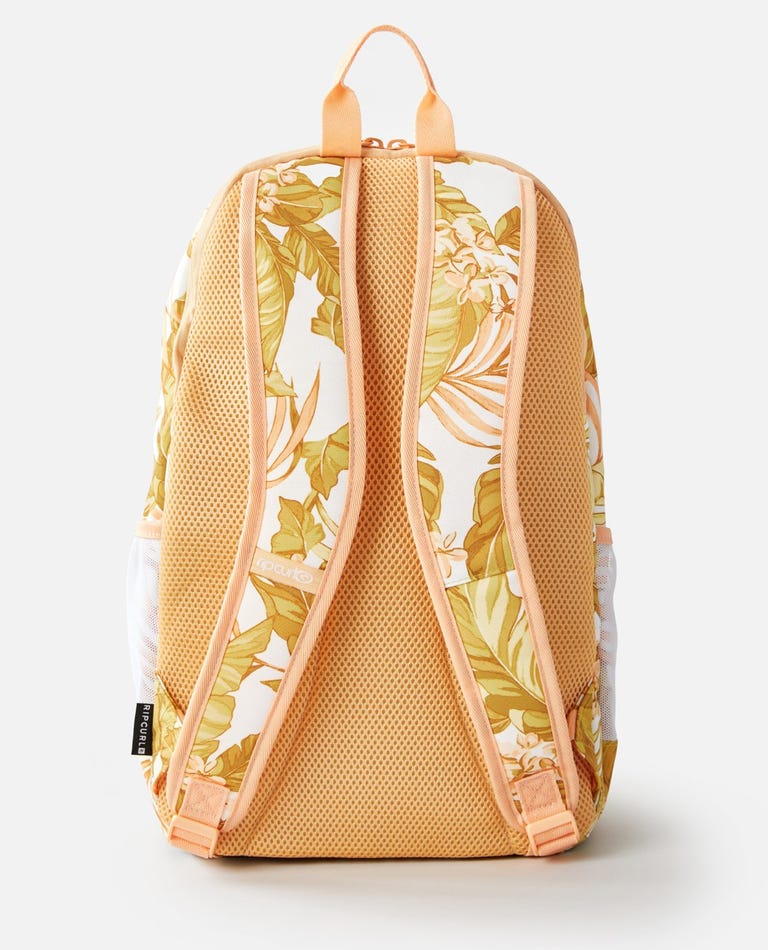 The Rip Curl Ozone 30L Multi Backpack in peach and white features a tropical leaf pattern, adjustable shoulder straps, a ventilated mesh back, and an insulated cooler compartment. A black label with text decorates the bottom strap of this stylish accessory.