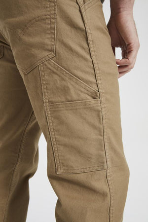 A close-up image of a person wearing Levis Workwear 505 Utility Pant in khaki color. The photo emphasizes the side and back pockets, showcasing the intricate stitching and rugged pockets. The fabric looks robust, and part of the person's hand is visible in the frame.