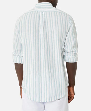 Rear view of someone wearing Industrie The Linenman Shirt, a relaxed fit, light blue and white striped long-sleeve button-up. The sleeves are rolled up for a laid-back look paired with white shorts.