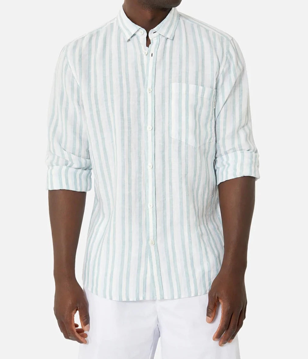 A person wearing the "Industrie The Linenman Shirt," featuring light blue and white vertical stripes, a button-down collar, and long sleeves, pairs it with white pants against a plain white background.
