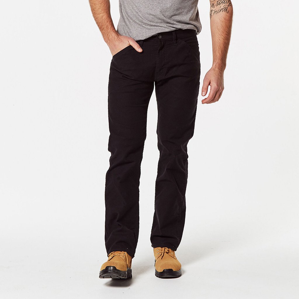 A person in a gray short-sleeve shirt and black Levis Workwear 511 Utility Slim Jeans stands with one hand in their pocket. They are wearing light brown shoes, and a tattoo is visible on their right arm. The background is plain white.