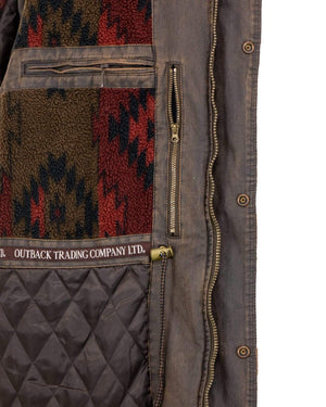 Close-up of the interior of an Outback Ranchers Jacket revealing detailed stitching, quilted lining, and intricate patterns. A tag on the inner pocket reads "Outback Trading Company Ltd." The interior pocket features a zipper and a colorful southwestern-style fabric design.