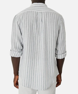 A person is shown from the back, wearing the Industrie The Paglia Long Sleeve Shirt in light gray with dark stripes. The shirt's sleeves are rolled up and is worn over white pants against a simple, light background.