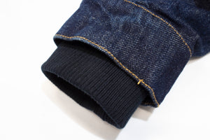 Close-up of the Pilbara Ladies Denim Jacket's cuff, showcasing yellow stitching and ribbed black fabric lining, crafted from 100% cotton against a white background.